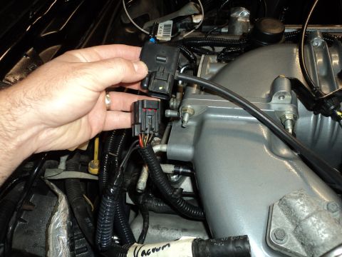 2004 Mercury Grand Marquis - Disconnecting an electrical connector from an engine part, showing wiring and component details.