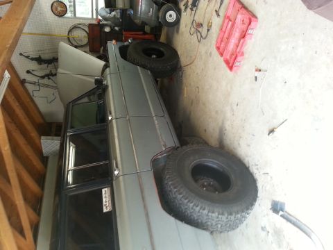 1982 Jeep Wagoneer - 1982 Jeep Wagoneer in a garage, hood open, with a spare tire nearby.