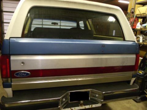1984 Ford Bronco - Rear view of a 1984 Ford Bronco, showing its distinctive blue and white paint scheme and Ford badging.