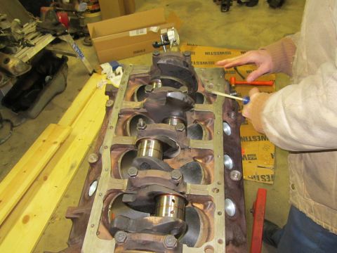 1984 Ford Bronco - Close-up of an engine block and crankshaft with tools nearby, suggesting mechanical work.