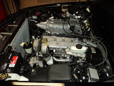 2004 Mercury Grand Marquis - Engine bay with a supercharger installed, showing the radiator, battery, and engine components.