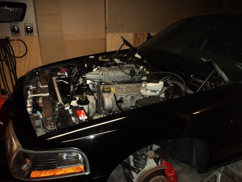 2004 Mercury Grand Marquis - Engine bay of a black car a supercharger, with the hood open.