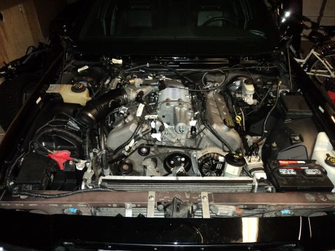 2004 Mercury Grand Marquis - The engine bay of a car is open, revealing a supercharged V8 engine with various hoses and components.