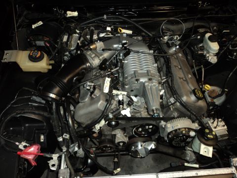 2004 Mercury Grand Marquis - Engine bay a supercharger, air intake, and numerous electrical connections.