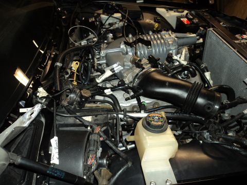 2004 Mercury Grand Marquis - Close-up view of a modified engine bay, showing a supercharger and intake system.