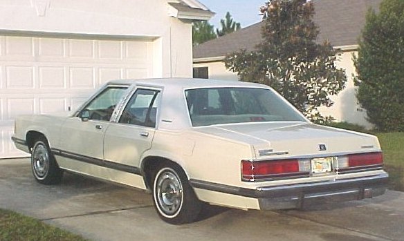 Cream 1989 Mercury Grand Marquis rear view. Visible text: SUPERMOTORS