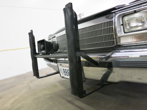 1991 Ford LTD Crown Victoria - Low-angle front view of a dark car fitted with a black push bar and spotlight, showing a California license plate above the chrome bumper.