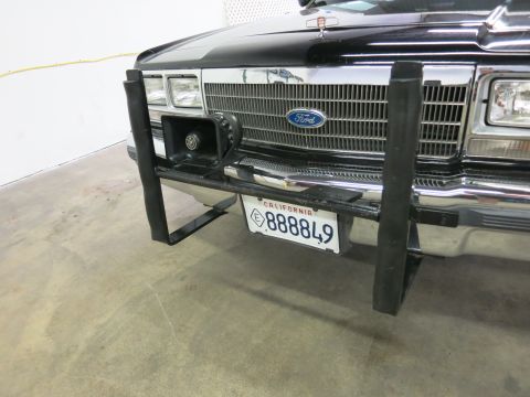 1991 Ford LTD Crown Victoria - Front of a black Ford with a tubular push bar and spotlight, displaying a California exempt license plate numbered 888849.