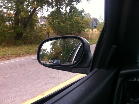 2003 Ford Crown Victoria - View from the passenger side of a vehicle, looking out the side mirror at the passing scenery.