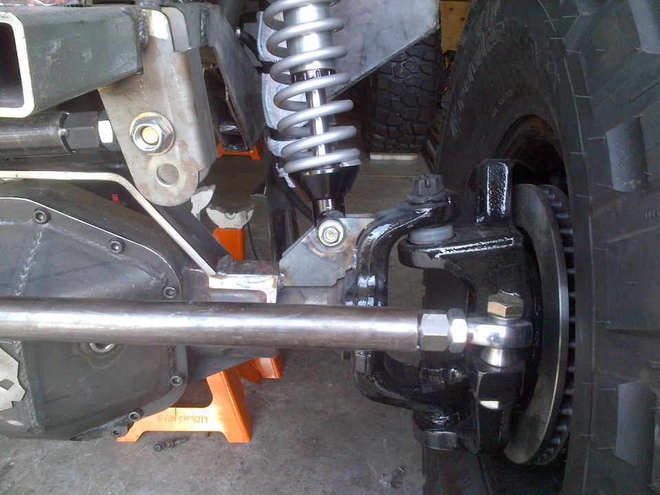 Off-road vehicle suspension and steering components, including differential, coilover shock, and tie rod.