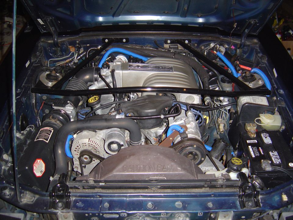 1989 Ford Mustang engine bay with blue hoses and strut tower brace