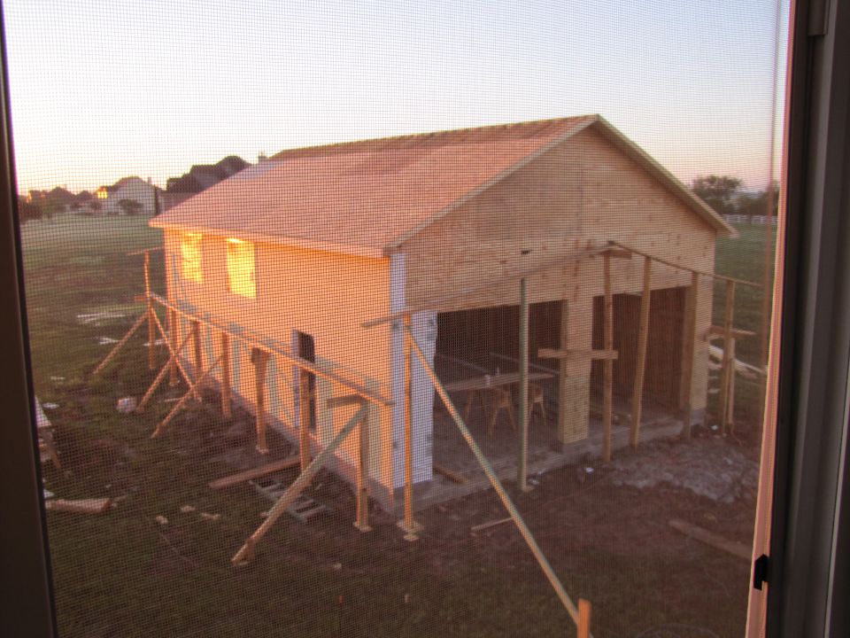 Construction of a wooden building at sunset.