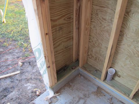 1995 Ford Bronco - This image shows the interior framing of a structure under construction, with plywood walls and wooden studs. A white plastic vapor barrier…
