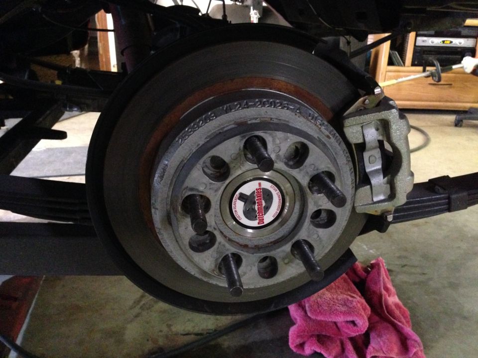 Close-up of a vehicle's rear brake assembly with a Dutchman Axles sticker on the hub.