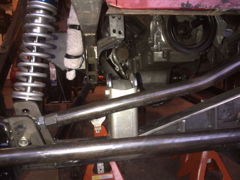 Undercarriage of a Jeep CJ7 showing coilover shock, suspension, and engine components.