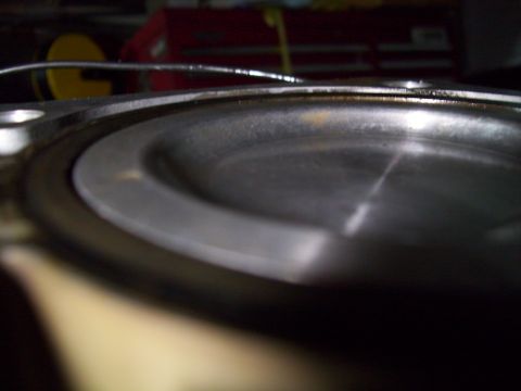 1995 Ford Probe - A close-up, low-angle shot of a metallic, circular engine part, possibly a piston or cylinder head, with a slightly worn surface and some l…
