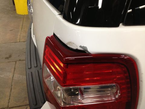 1991 Ford LTD Crown Victoria - Detail photograph of an SUV taillight and rear bumper, not a technical document.