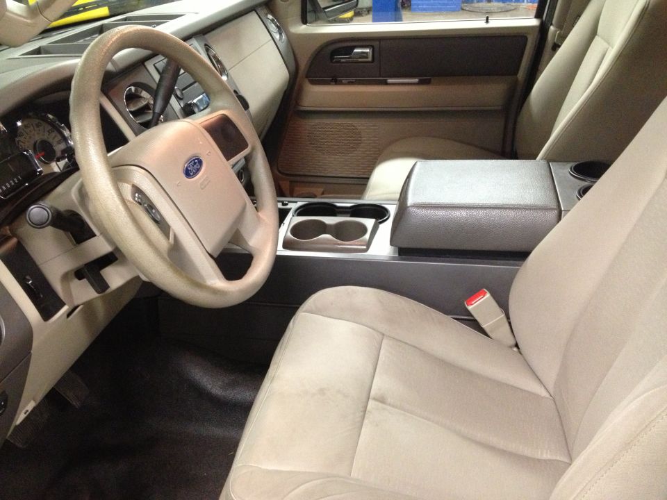 Photo of a tan SUV interior showing steering wheel, dash and front seats