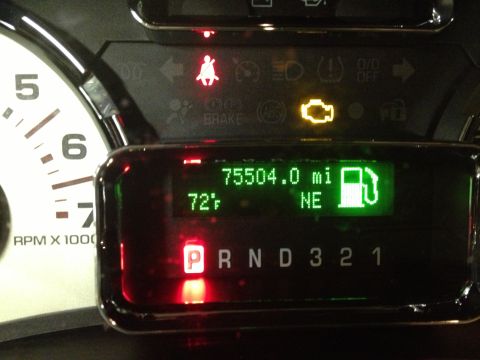1991 Ford LTD Crown Victoria - Photograph of a vehicle gauge cluster display reading 75504 miles with warning lights illuminated, not a technical document.