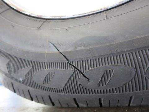 1991 Ford LTD Crown Victoria - Photograph of a damaged tire with a split running across the sidewall, not a technical document.