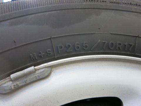 1991 Ford LTD Crown Victoria - Photograph of a tire sidewall showing the molded size marking P265/70R17, not a technical document.