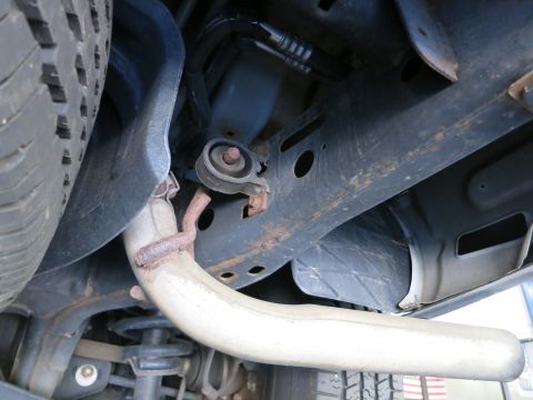 1991 Ford LTD Crown Victoria - Photograph of a vehicle's underside showing exhaust piping and suspension mounts, not a technical document.