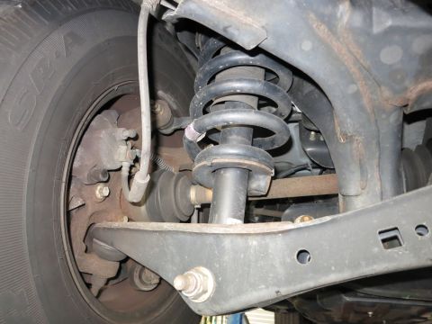 1991 Ford LTD Crown Victoria - Photograph of a vehicle's front suspension and brake assembly, not a technical document.