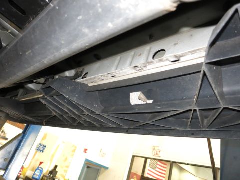 1991 Ford LTD Crown Victoria - Photograph of a vehicle's underside step assembly seen on a lift, not a technical document.