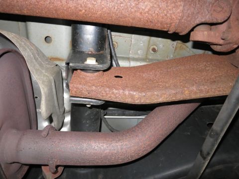 1991 Ford LTD Crown Victoria - Photograph of a vehicle's rusted exhaust pipe and frame bracket, not a technical document.
