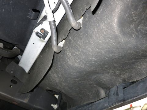1991 Ford LTD Crown Victoria - Photograph of a vehicle's underside showing tank, hoses and fuel lines, not a technical document.