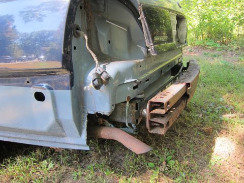 2001 Ford Crown Victoria - The rear passenger side of a dark blue Ford Crown Victoria is shown with significant damage to the bumper and surrounding body panels. A ru…