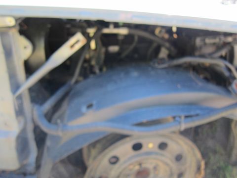 2001 Ford Crown Victoria - This is a close-up, slightly blurry view of the front wheel well area of a vehicle. The fender liner is visible, along with various hoses a…