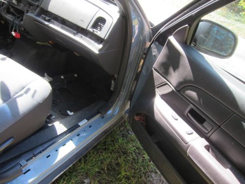 2001 Ford Crown Victoria - The interior of a grey 2001 Ford Crown Victoria is shown with the driver's side door open. The dashboard and door panel are visible, along…