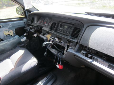 2001 Ford Crown Victoria - The interior of a dismantled 2001 Ford Crown Victoria shows the dashboard with the center console removed, exposing wiring. The driver's se…