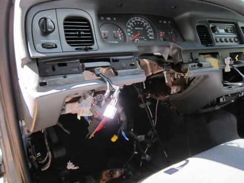 2001 Ford Crown Victoria - The interior of a disassembled car dashboard shows exposed wiring and components. The dashboard is partially removed, revealing the underly…
