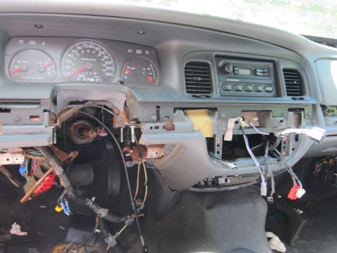 2001 Ford Crown Victoria - The interior of a dismantled 2001 Ford Crown Victoria dashboard is shown, with exposed wiring and components. The instrument cluster and ra…