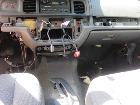 2001 Ford Crown Victoria - The interior of a disassembled dashboard in a vehicle, showing exposed wiring, vents, and the glove compartment.