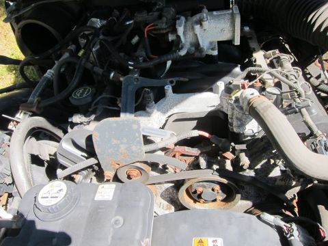 2001 Ford Crown Victoria - A close-up view of the engine bay of a 2001 Ford Crown Victoria, showing various hoses, belts, and engine components. The engine appears to…