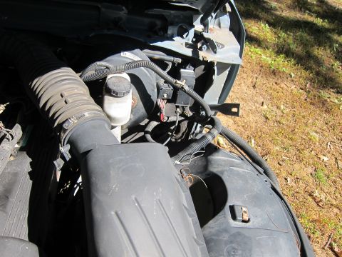 2001 Ford Crown Victoria - A close-up view of the engine bay of a 2001 Ford Crown Victoria, focusing on the air intake system and brake fluid reservoir. The vehicle i…