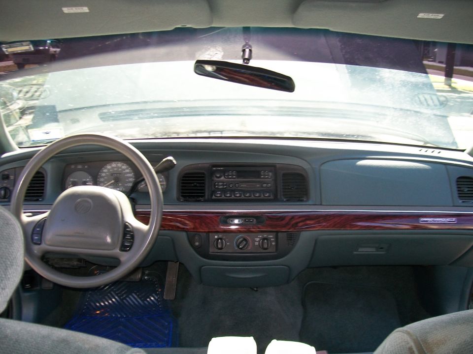 Interior of a 1995 Mercury Grand Marquis dashboard with wood grain trim.