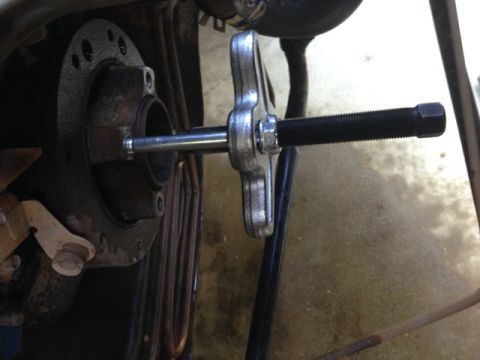 1996 Ford Bronco - A puller tool is attached to a timing chain cover, likely for removal or installation.