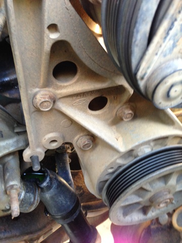 1996 Ford Bronco - Engine bracket with Ford logo, pulleys, and hoses visible in the engine bay.