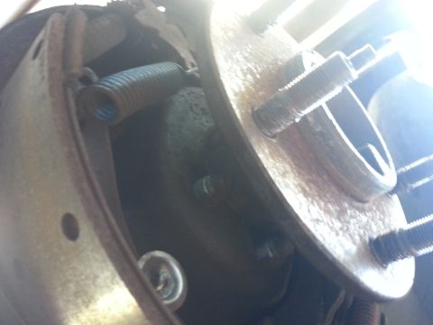 1994 Ford Bronco - Close-up view of a vehicle's rear brake assembly, showing a spring and lug bolts. The registry label may be incorrect.