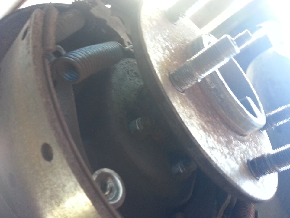 Rear brake assembly with spring and lug bolts