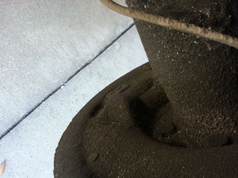 1994 Ford Bronco - Close-up of a dusty brake rotor and caliper assembly, with a wire overhead.