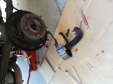 1994 Ford Bronco - Drum brake components laid out on cardboard for repair or inspection.