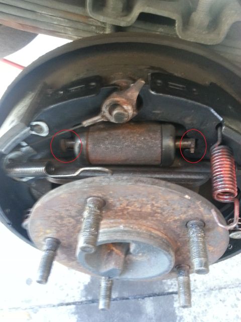 1994 Ford Bronco - Close-up view of a vehicle's rear drum brake assembly, showing the wheel cylinder and brake shoes.