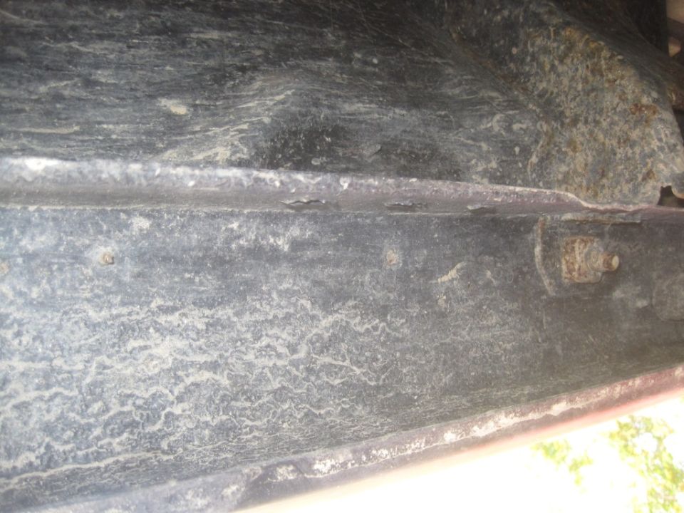 Underside frame detail with rust and dirt. Supermotors.net logo visible