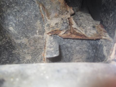1993 Ford Bronco - Close-up view of a heavily rusted metal frame component, likely from a vehicle's undercarriage.