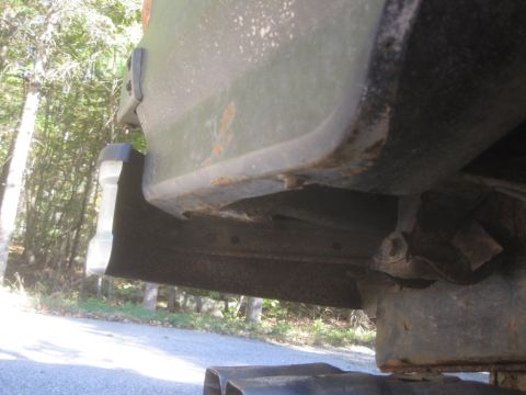 1993 Ford Bronco - Close-up view of a rusted vehicle frame and bumper corner, showing signs of wear.